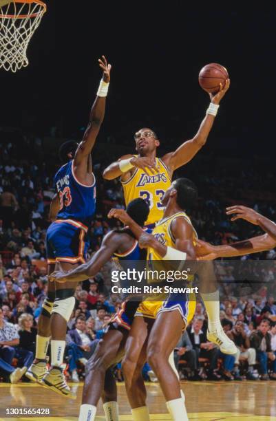 Kareem Abdul-Jabbar, Center for the Los Angeles Lakers jumps to make a lay up shot to the basket over Patrick Ewing of the New York Knicks during...