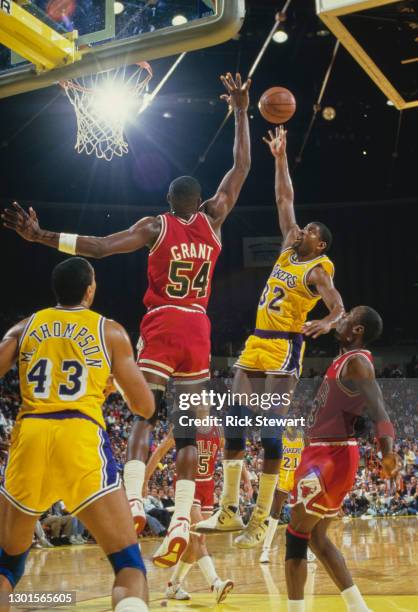 Earvin "Magic" Johnson, Shooting Guard and Power Forward for the Los Angeles Lakers jumps to make a lay up shot to the basket as Horace Grant of the...