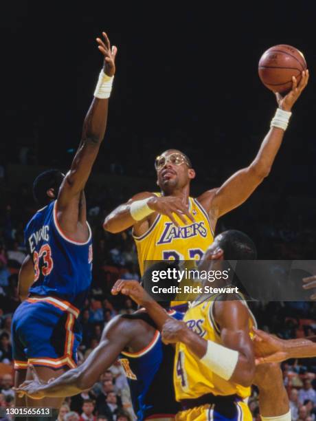 Kareem Abdul-Jabbar, Center for the Los Angeles Lakers jumps to make a lay up shot to the basket over Patrick Ewing of the New York Knicks during...