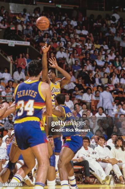 Earvin "Magic" Johnson, Shooting Guard and Power Forward for the Los Angeles Lakers attempts a jump shot 3 pointer to the basket during the NBA...