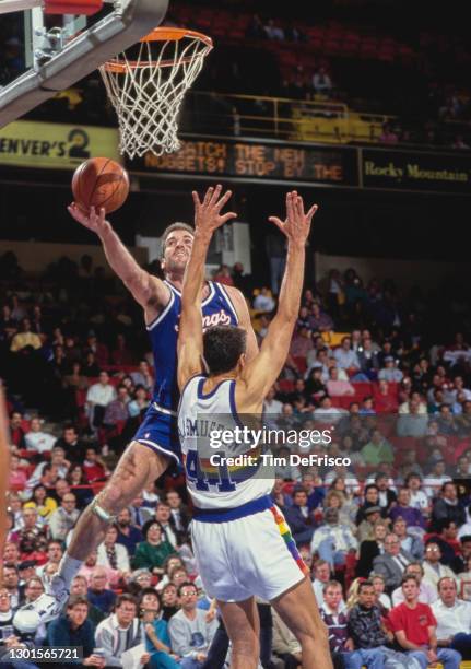 Bill Wennington, Center for the Sacramento Kings drives to the basket to make a one handed layup to the net as Blair Rasmussen of the Denver Nuggets...