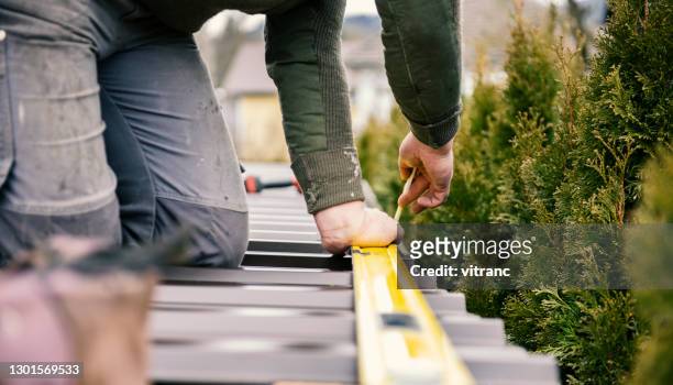 roofer taking measure of sheet metal plank with a pencil - sheet metal stock pictures, royalty-free photos & images