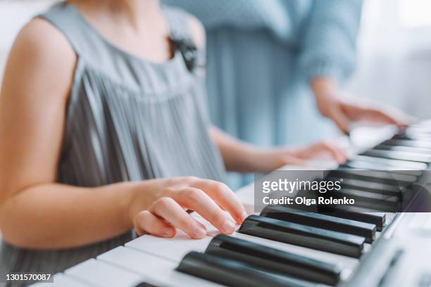 little girl have music piano lesson with her female teacher at home - pianist stock pictures, royalty-free photos & images