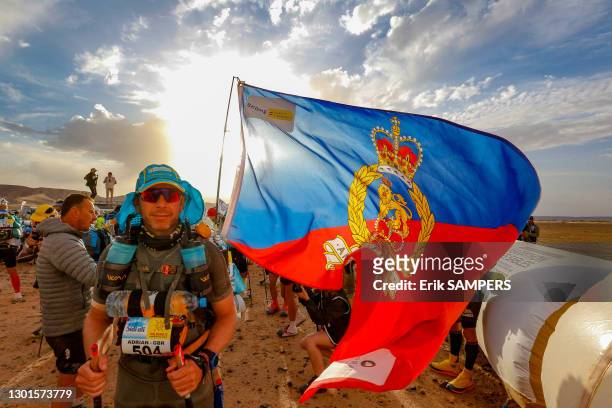Le coureur britannique Adrian Lucas portant un drapeau avec les armoiries royales du Royaume-Uni lors du Marathon des Sables, 12 avril 2019, Maroc.