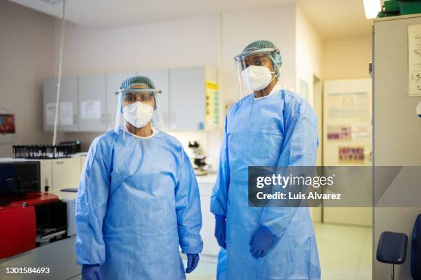 scientists in ppe suit standing together in the lab - radiation suit stock pictures, royalty-free photos & images