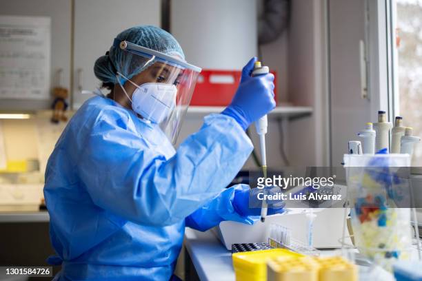 medical scientists wearing coverall and ppe working in lab - medical research mask stock pictures, royalty-free photos & images