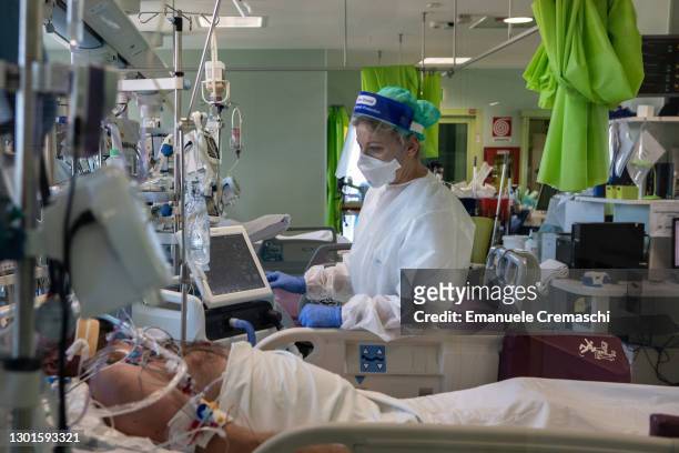 Doctor Annalisa Malara, wearing PPE , stands next to a patient in the COVID-19 Intensive Care Unit of the Ospedale Maggiore di Lodi, during a visit...
