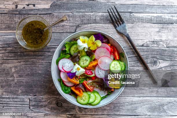 bowl of mixed salad with edible flowers - salad bowl stock pictures, royalty-free photos & images