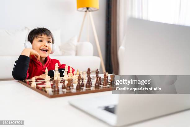 Kid Boy With Glasses Playing Online Chess Board Game On Computer
