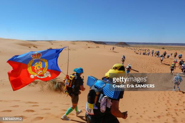 Le coureur britannique Adrian Lucas portant un drapeau avec les armoiries royales du Royaume-Uni lors du Marathon des Sables, 7 avril 2019, Maroc.