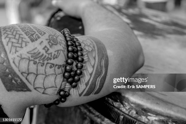 Bras d'un homme portant un tatouage traditionnel et un bijou, 24 juin 2002, Iles Marquises, Polynésie française.