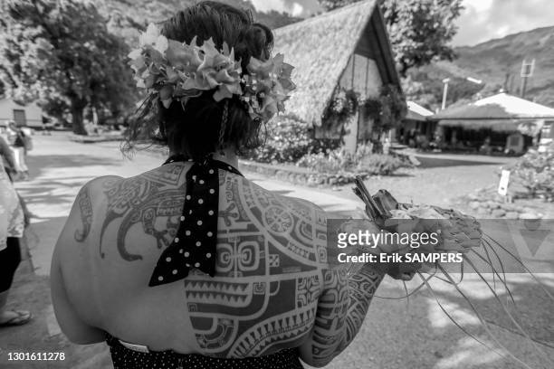 Femme portant un plat avec un tatouage traditionnel sur le dos, 24 juin 2002, Iles Marquises, Polynésie française.