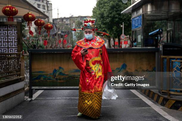 Sheraton hotel employees wear protective masks whilst dressed as the Chinese God of wealth, prepare to deliver takeaway meals to customers at the...