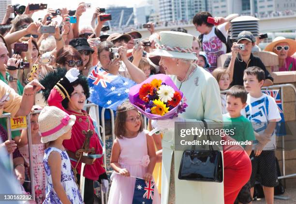 Queen Elizabeth II recieves flowers from children at Southbank on October 24, 2011 in Brisbane, Australia. The Queen and Duke of Edinburgh are on a...