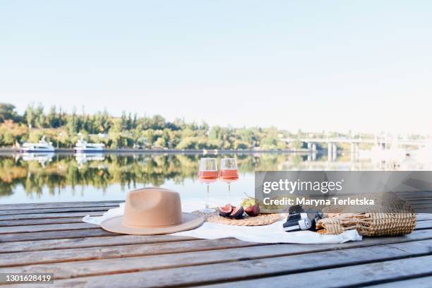 picnic at the pier near the water. - strohhut stock-fotos und bilder