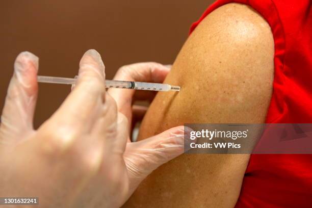 Syringe with vaccine being injects into person's arm, Covid-19 vaccinations, Pfizer and Moderna vaccines were issued FDA emergency use authorization...