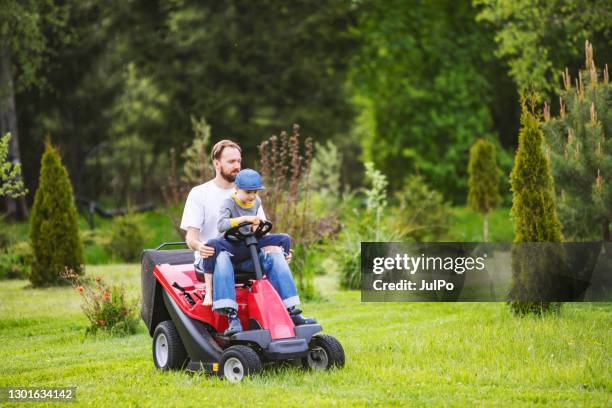 father and son on riding mower - lawnmower stock pictures, royalty-free photos & images