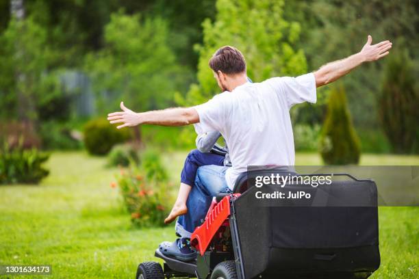 father and son on riding mower - riding lawnmower stock pictures, royalty-free photos & images