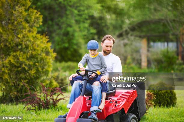 father and son on riding mower - tractor mower stock pictures, royalty-free photos & images