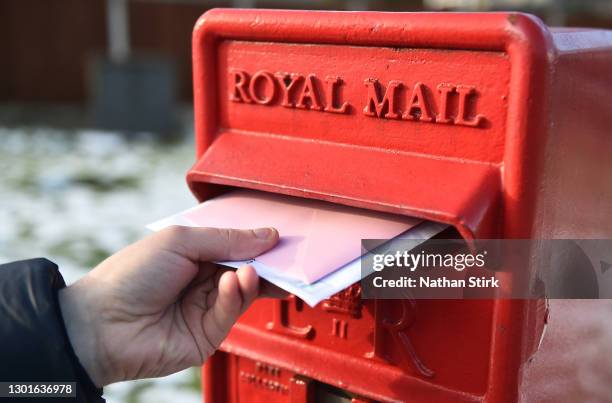 Letters are posted into a Royal Mail post box on February 11, 2021 in Bradford, England .