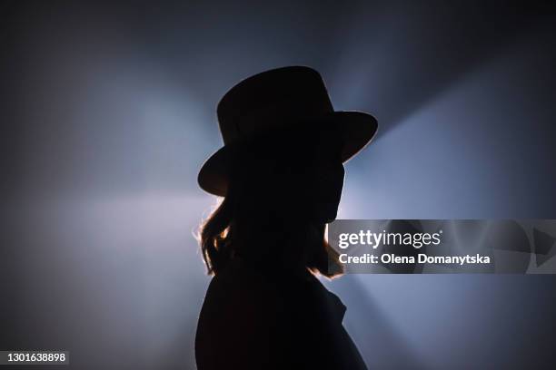 silhouette of a girl in a hat in a backlight - empty face female foto e immagini stock