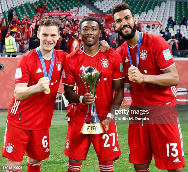 Joshua Kimmich, David Alaba and Eric Maxim Choupo-Moting of Muenchen pose with the trophy after winning the FIFA Club World Cup Qatar 2020 final...