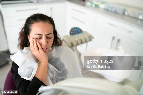 the woman going to the dentist is sitting writhing in pain - gingivitis stock pictures, royalty-free photos & images