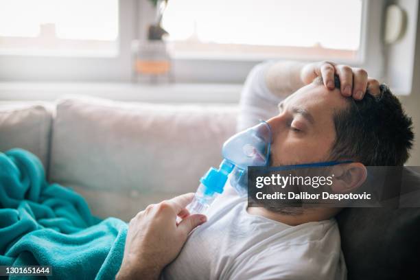 a man in despair wears a mask hoping he will be better - copd patient stockfoto's en -beelden