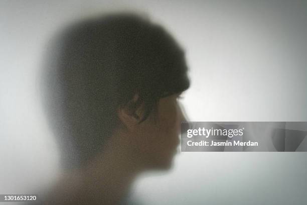 person behind shadow glass - guy with face in hands stockfoto's en -beelden