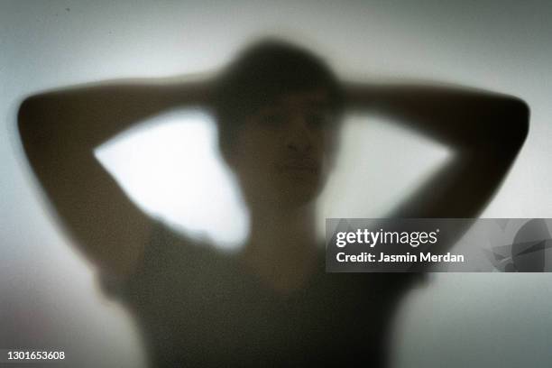 person behind shadow glass - frosted glass stockfoto's en -beelden