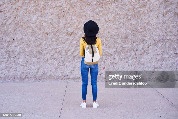 rear view of a young woman wearing a backpack - andersdahl65 stock pictures, royalty-free photos & images