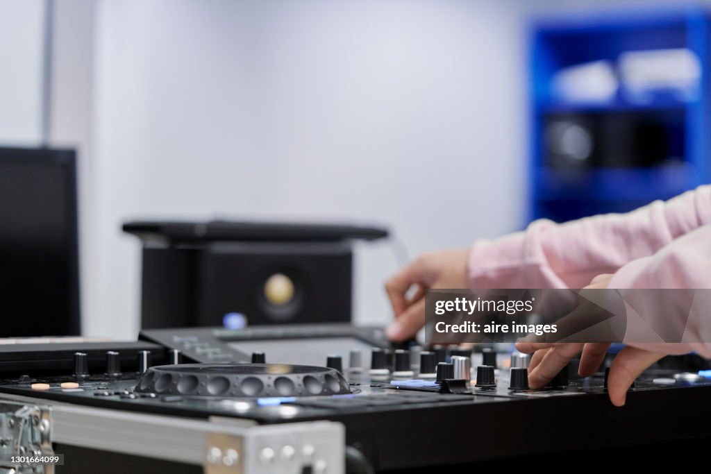 Dj working with a professional sound mixer console.