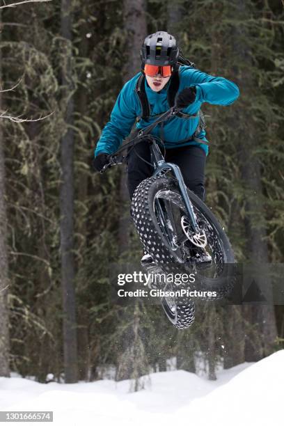 winter fat bike jump - canmore stock pictures, royalty-free photos & images