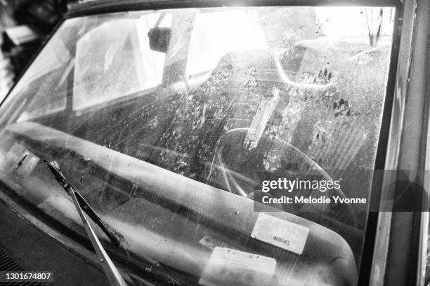 black and white close up driver's front side view of windshield on old classic car in garage - scheibenwischer stock-fotos und bilder
