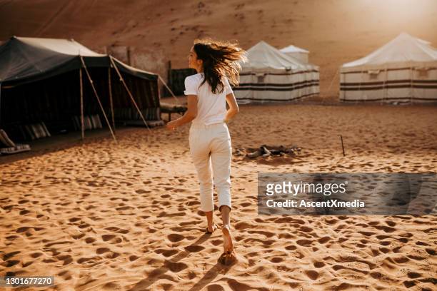 de jonge vrouw ontspant buiten camping bij zonsopgang - desert camping stockfoto's en -beelden