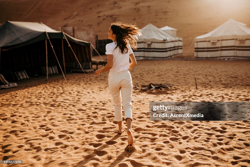 Young woman relaxes outside campsite at sunrise