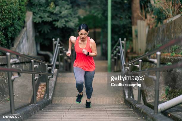 young female athlete running up stairs - staircase stock pictures, royalty-free photos & images