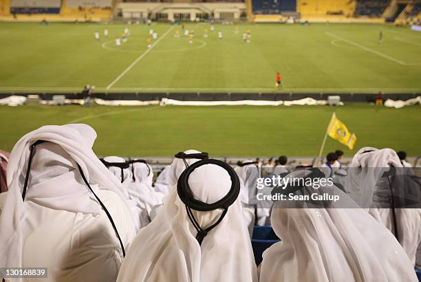 Fans wearing traditional local dress attend the Gharafa vs. Kharaitiyat Qatar Stars League football match at Al Gharafa Stadium on October 23, 2011...