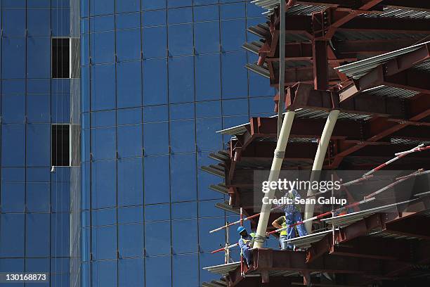 Workers maneuver a part into place on a construction site in the budding new financial district on October 23, 2011 in Doha, Qatar. Qatar will host...