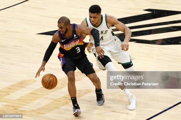 Chris Paul of the Phoenix Suns handle the ball against Giannis Antetokounmpo of the Milwaukee Bucks during the second half of the NBA game at Phoenix...