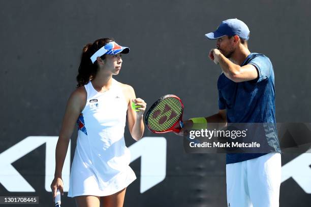 Ena Shibahara and Ben McLachlan of Japan talk tactics in their Mixed Doubles first round match against Laura Siegemund and Kevin Krawietz of Germany...