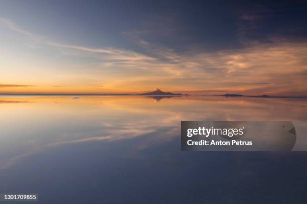 sunset at salar de uyuni in the rainy season, aitiplano, bolivia - uyuni stock-fotos und bilder