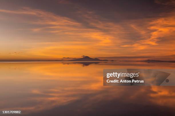 sunset at salar de uyuni in the rainy season, aitiplano, bolivia - bolivian navy stock pictures, royalty-free photos & images