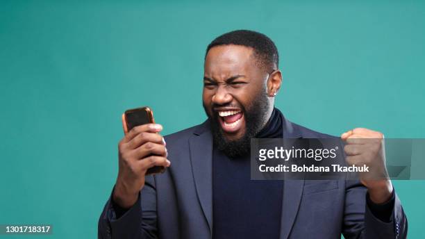 man looks into smartphone surprises and rejoices happiness - see background stock pictures, royalty-free photos & images