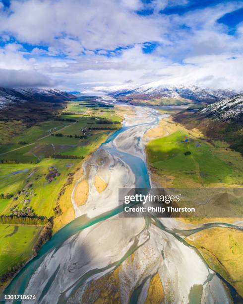 river braids and glacial snow melt run off from mountains into valley - river aerial view stock pictures, royalty-free photos & images