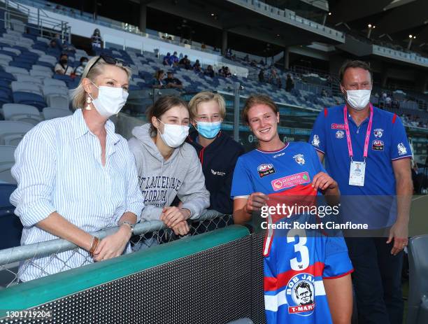 Isabella Grant of the Bulldogs poses with her father Chris Grant and her family after being presented her match jersey during the round three AFLW...