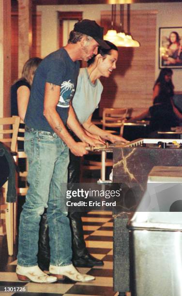 Newly married Billy Bob Thornton and Angelina Jolie play pinball at Jerry''s Famous Deli June 3, 2000 in Studio City, CA.