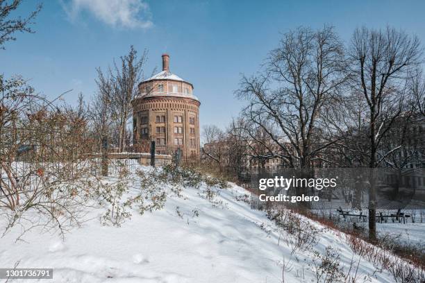 water tower on snow capped hill in berlin prenzlauer berg on sunny winter day - berlin winter stock pictures, royalty-free photos & images