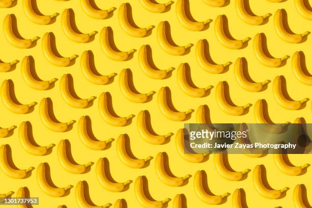 many bananas on a yellow background - frühstück freisteller stock-fotos und bilder