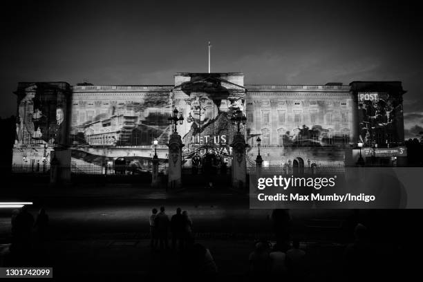 Photograph showing the then Prime Minister Winston Churchill, alongside other war-time photographs, is projected onto the facade of Buckingham Palace...